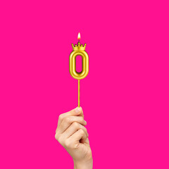 Birthday on a fuchsia background with the number 0 - Hands holding number-shaped candles
