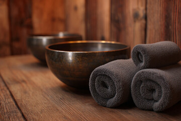 Relaxing ambiance with singing bowls and rolled towels in a spa setting, perfect for wellness and meditation sessions