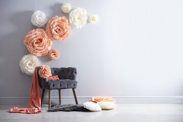 Photo zone with stylish floral decor and armchair in studio, space for text
