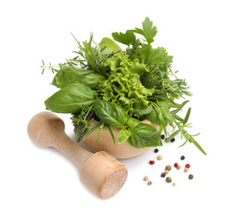 Mortar with pestle, different aromatic herbs and spices isolated on white