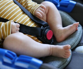 Cute little baby fastened in car seat, closeup