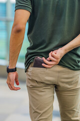 A man puts a leather wallet into his back pocket, perfect for a leather products catalog design.