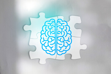 Conceptual illustration of human brain symbol divided into left and right hemispheres on connected jigsaw puzzle pieces. Represents cognitive function, problem solving, mental health