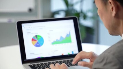 Businessman in smart casual suit working on laptop at modern desk, screen showing marketing analytics dashboard and customer graphs
- Powered by Adobe