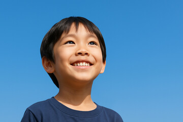 青空と笑顔の楽しそうな小学生の子ども アジアの日本人の男の子