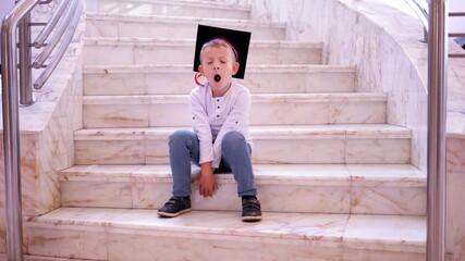 Little child with graduation cap sit on stairs worried of obscure future, early graduation, conceptual - Powered by Adobe