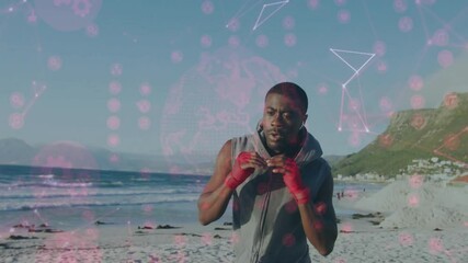 Tightening red wraps slipping earphones boxer punching with pink icons on beach for training - Powered by Adobe