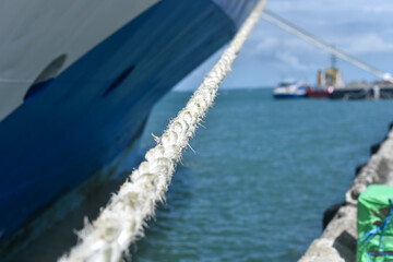 Rope tied to a ship close up on the background of the ship's side.	
