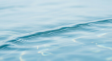 Close-up of clear, rippling water surface, showing subtle light reflections and gentle movement.