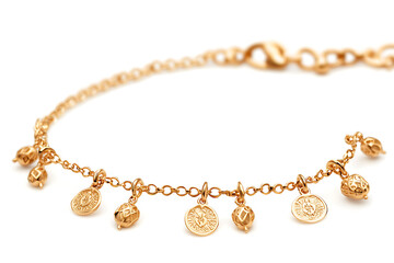 Elegant gold bracelet showcases intricate detailing and delicate charms on a bright white background perfect for showcasing jewelry.