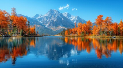 Fototapeta premium Mountain peak reflections in still lake, framed by autumn foliage, clear skies above