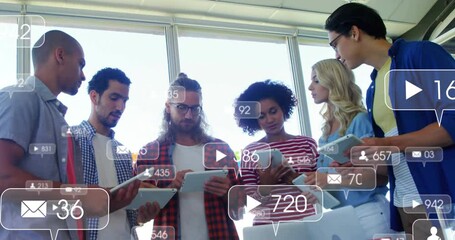 Six colleagues gathering at meeting table tracking media metrics icons fading on tablets - Powered by Adobe