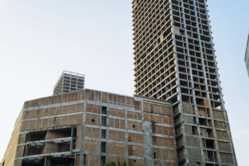 Facade of residential or business multi-story building skyscraper under construction. Incomplete or...
