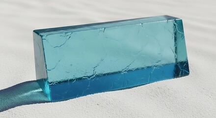 Rectangular block of aquamarine translucent ice on a white textured surface