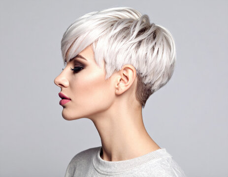 Fashionable female with buzz cut hairstyle showcases modern and stylish look. short, platinum blonde hair highlights her facial features beautifully, exuding confidence and elegance