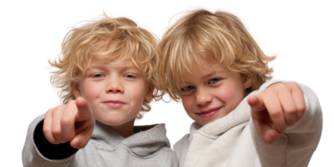 Two cheerful boys with blonde, curly hair are playfully pointing at camera, showcasing their playful personalities and bright smiles