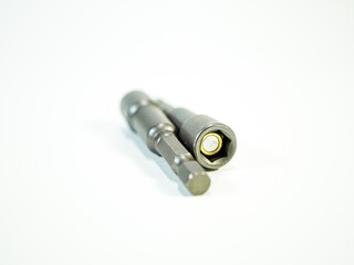 Close up view of magnetic drill bits resting on a white surface, construction and repair tools.