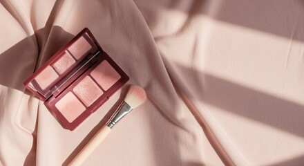 Makeup palette and brush on beige fabric