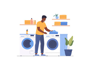 Smiling Man Doing Laundry Folding Clothes in a Laundry Room.