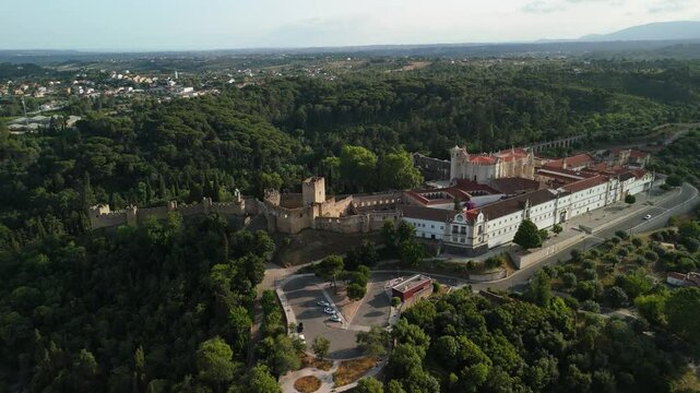 Drone ascends, pulling back to reveal Castelo de Tomar and Convento de Cristo amid hills