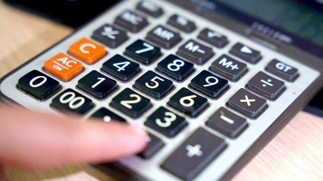 Finger presses calculator button in fast motion&mdash;ideal for financial, tax, business, or school themes.