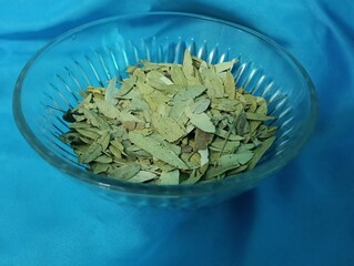 dried Senna leaves close up photo on blue background, commonly used in herbal medicine,...