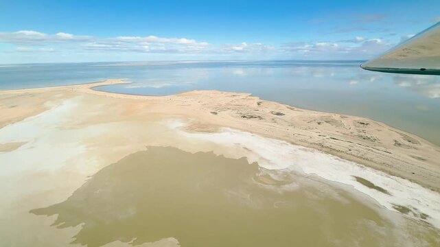 Aerial footage captured from a Cessna aircraft over Lake Eyre in the South Australian Outback. Witness the beautiful sight of this salt lake filling with water, reflecting the serene blue sky.