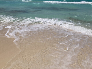 clear turquoise waves washing onto sandy beach shore