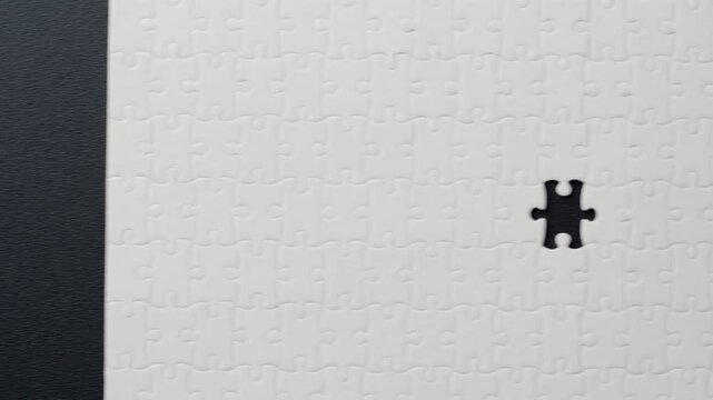 White jigsaw parts lying dark background forming incomplete structure closeup