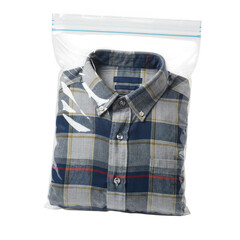 Folded blue and grey plaid button down shirt inside a clear plastic ziploc bag isolated on transparent background