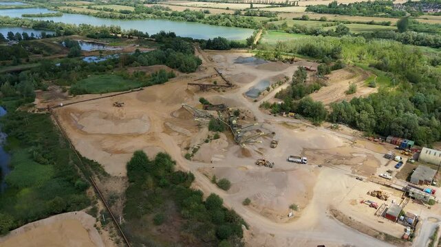 Aerial drone perspective of a quarry mining area with heavy machinery and aggregates minerals extraction in rural landscape near Little Paxton England UK
