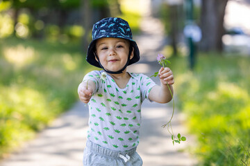 Smiling Toddler Holding Flowers Outside in a Sunny Vancouver Park