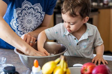 Young Boy Toddler Cooking with Adult in a Home Kitchen Setting