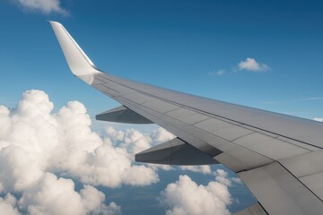 Fototapeta premium Commercial aircraft wing soaring through blue sky representing aviation industry and travel transportation freedom