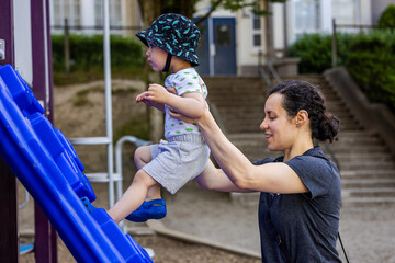 Mother Helping Boy Toddler in Vancouver Playground Climb on Play Structure
