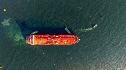 Aerial view oil ship tanker vessel loading and unloading in oil terminal station refinery, Global business import export logistic transport sea freight cargo tanker, Red crude oil tanker ship at port.