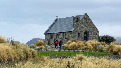 Woman making the heart symbol on the grounds of the Tekapo Chapel