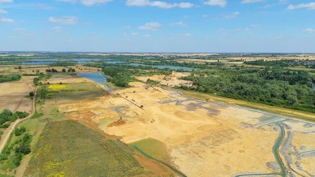 Aerial drone perspective of a quarry mining area with heavy machinery and aggregates minerals extraction in rural landscape near Little Paxton England UK