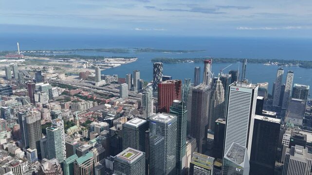 Drone flies through Toronto&rsquo;s Financial District toward Lake Ontario, passing Scotia Plaza, TD Tower, and BMO Tower with visible construction cranes and busy street traffic below
