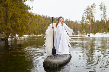 Girls in white dress role-playing winter themes on a serene lake surrounded by nature