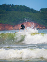 Caucasian male surfer in action, beautiful view in the background.