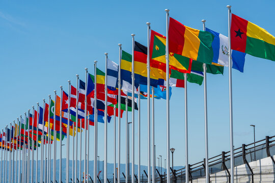 International Flags flying high against clear sky at the Yumeshima, an artificial island in Osaka Bay.