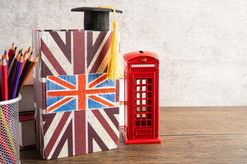 UK flag with graduate hat on english language book.