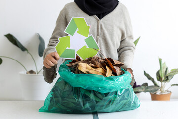 Portrait Of Person Hands Showing Recycling Symbol While Holding Plastic Bag With Dried leaves