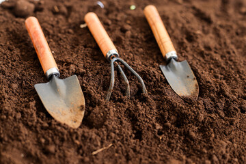 Close Up View Of Small Gardening Tools Lying On Freshly Tilled Dark Brown Dirt