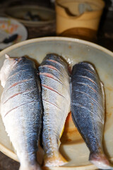 Cleaned raw fish on a white plate, showcasing freshness and culinary preparation