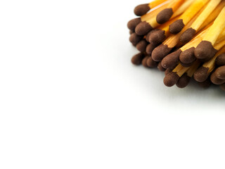 A collection of wooden matchsticks with brown heads grouped together against a white background. 