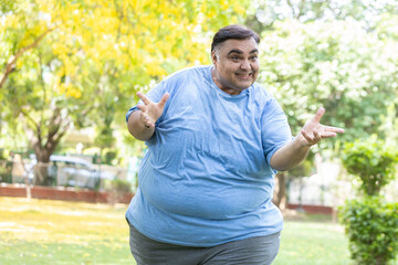 Happy overweight indian man looking at camera. energetic fat guy. Joyful plus size male. Obesity.