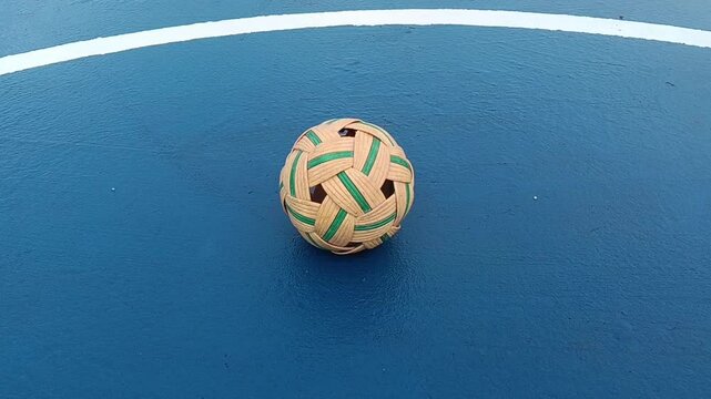 synthetic sepaktakraw or takraw or  buka ball, kick volleyball or foot volleyballball on blue background court , closeup of photo taken in malaysia.