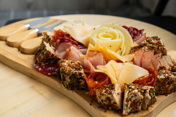Food trend gift aperitivo party idea. Appetizers wooden grazing board with different antipasti charcuterie snacks and cheese. Assorted cheese meat platter. Disordered eating. Girl dinner